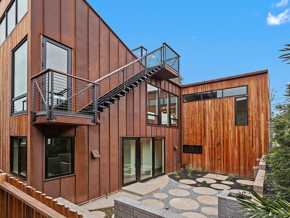 Outside of home facing west. Stairs to roof deck.