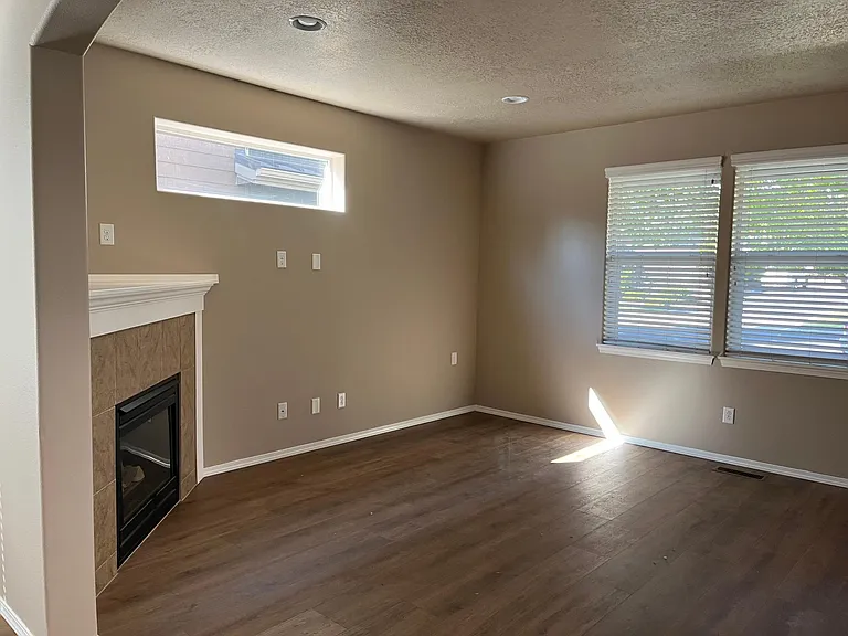 fireplace in the great room with hardwood floors, open floor plan, kitchen, bar and dinning area