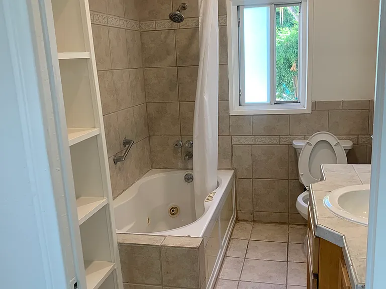 Full bath with shelving for towels and toiletries.