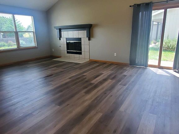 Vaulted Living Room with LVT flooring and gas fireplace.