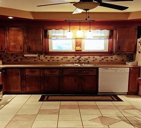 Warm kitchen includes custom tray ceiling, new ceramic floors, light fixtures and gorgeous back splash.