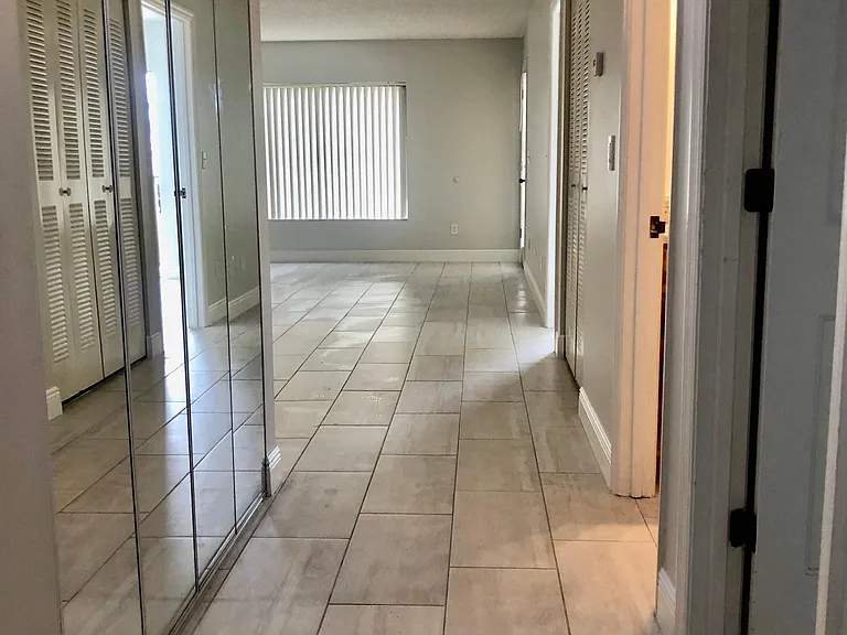 Entry with laundry closet on left behind mirrored doors. Room for full size washer dryer.