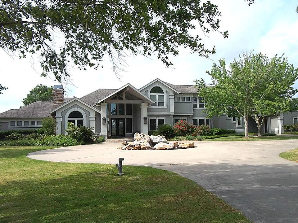 Front of home with circular drive and beautiful fountain in the middle