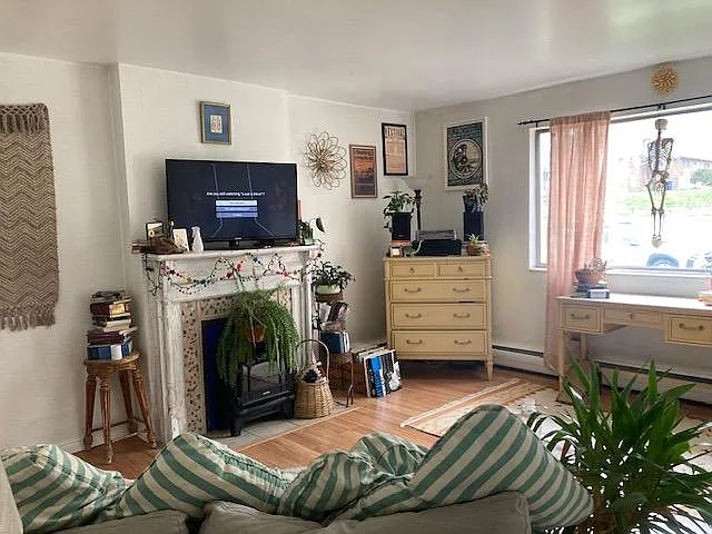 living room with fireplace mantel and east facing window