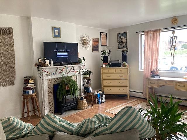 living room with fireplace mantel and east facing window
