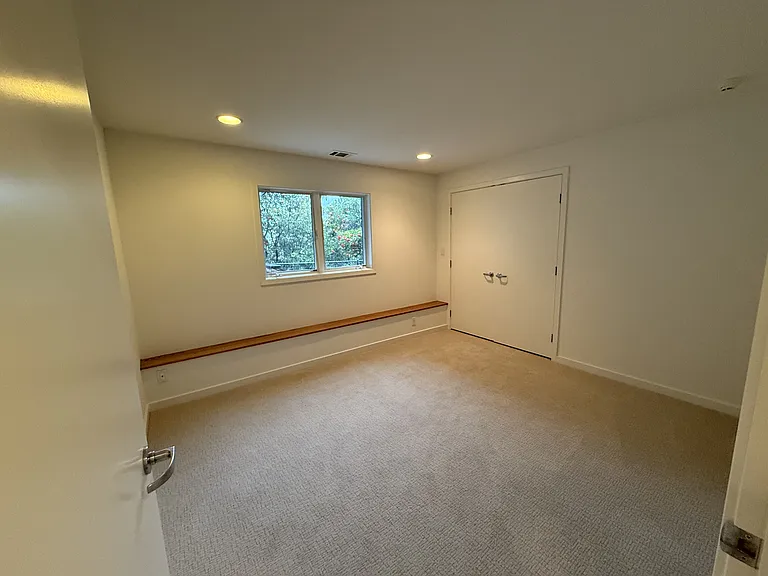 Third bedroom has a spacious closet and comfortable plush carpets, located adjacent to another hallway bathroom.