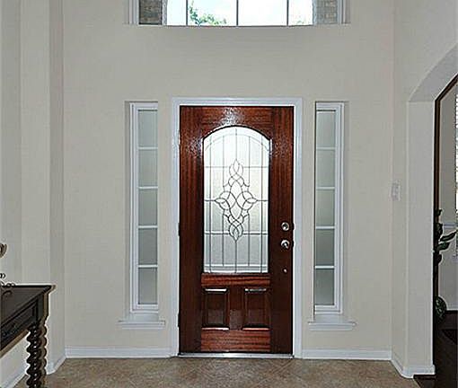 Gorgeous foyer with tiled entry and transome window