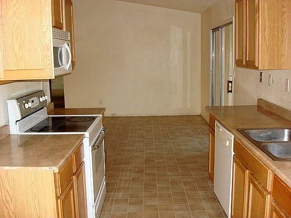 Kitchen with Newer white flat-top range, microwave and dishwasher