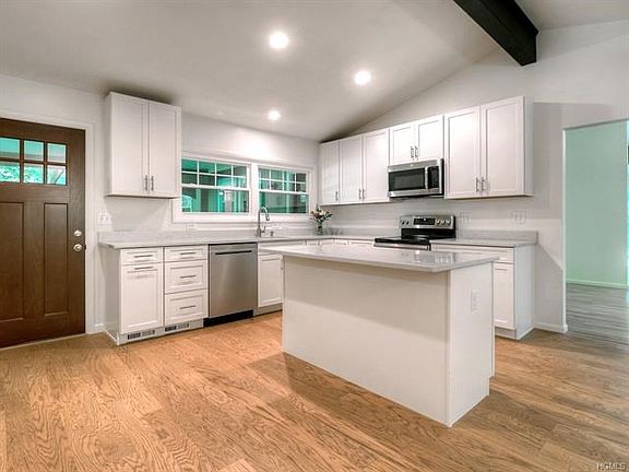 Brand new kitchen.  White shaker cabinets, soft close drawers, quartz countertops, stainless steel appliances, vaulted ceiling, recessed lights and hardwood floors.   Beautiful island can accommodate a few stools.