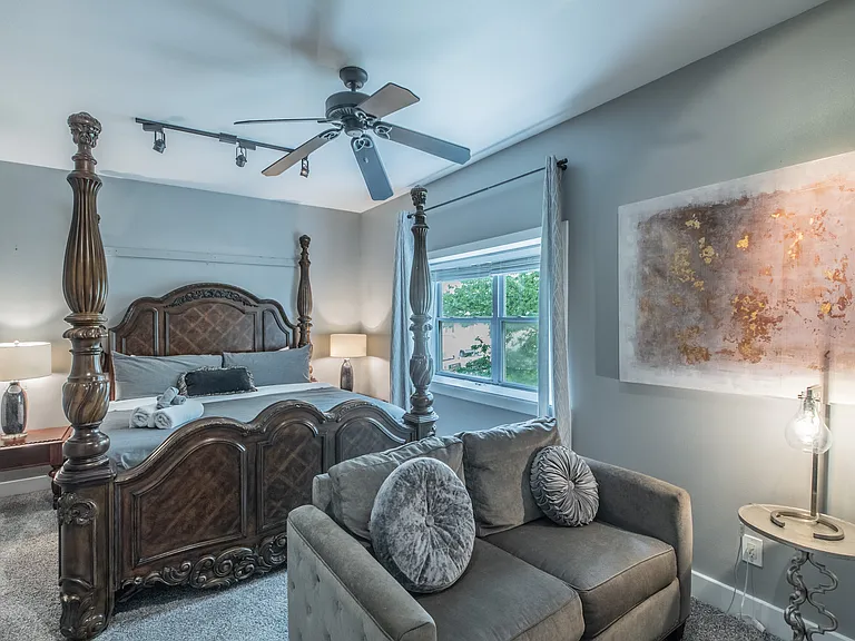 A spacious retreat featuring a grand bed and cozy seating.