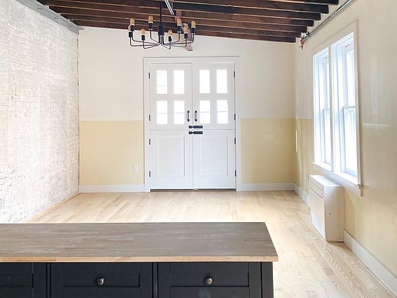 Living room with exposed brick and hayloft doors (closed)