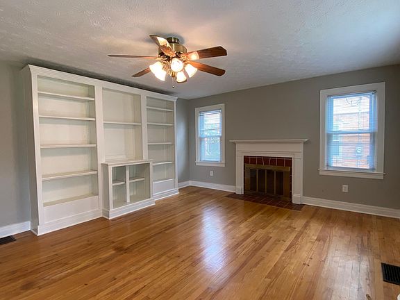 Front door enters into living room with hardwood floors and built in shelving. (Fireplace for decoration only.)