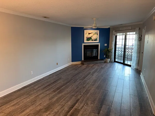 Picture appears much more narrow than room actually is. Large room had a full sized L shaped couch and dining table. Working fireplace. Property has extensive and high quality renovations throughout. Warm grained LVP flooring throughout