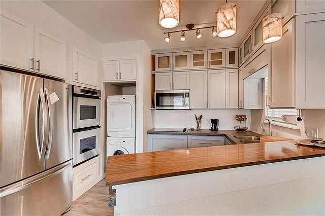 Remodeled Kitchen with custom cabinetry giving you tons of storage, poured concrete countertops, new pendent lighting, DOUBLE OVEN! Fridge, washer, and dryer all convey!!