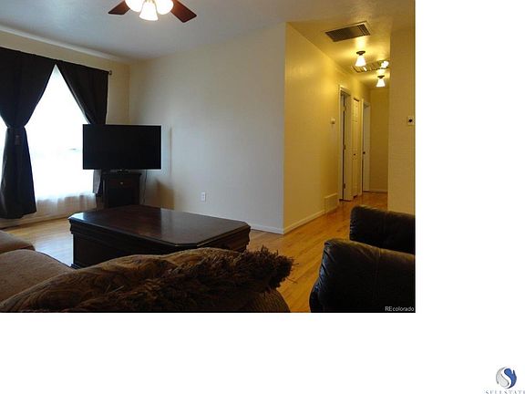Nice open floor plan living room with wood floors, newer windows and ceiling fan!