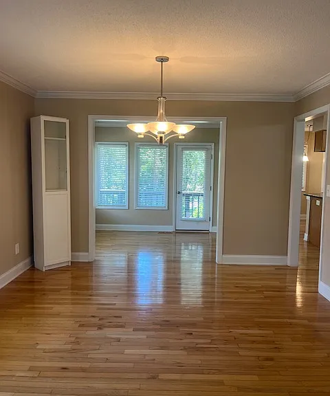 Open floor plan with window filled Carolina Room opens to small deck