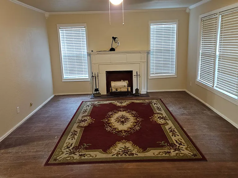 Large formal living room with fireplace and natural light