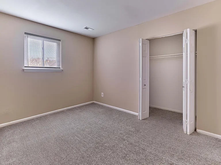 Cozy carpeted bedroom with generous closet space at Village Square.