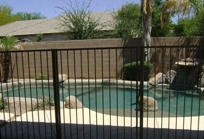 Backyard features a crystal blue pool with rock waterfall fe