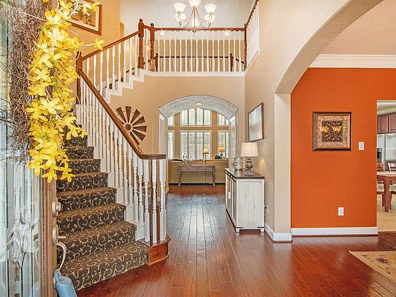 Upon entry, you'll notice a soaring ceiling, striking hardwood floors and beautifully carpeted stairs