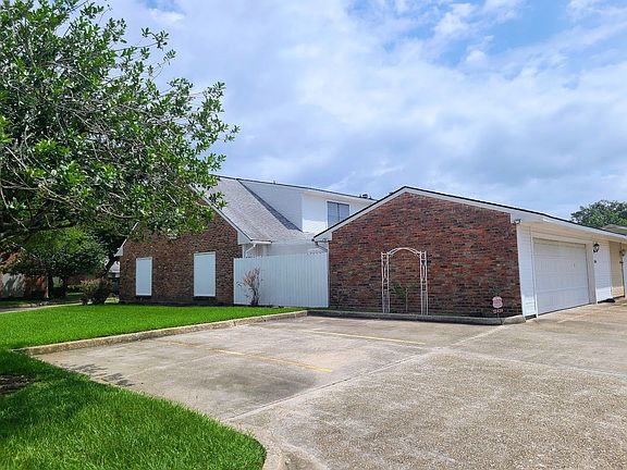 Side view of unit next to visitor parking. Half story windows of master bedroom.