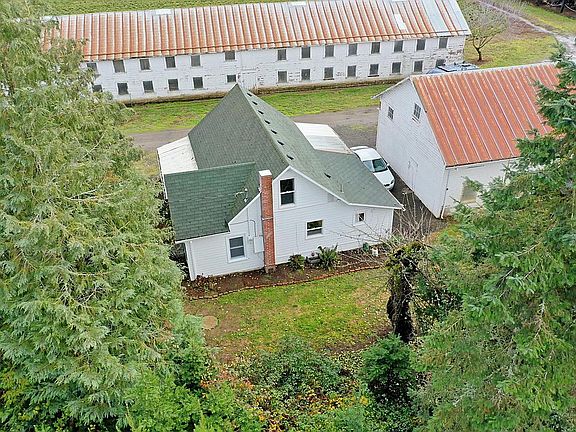 Aerial view the house from the West. View of one parking space to the right of the photo. The other parking space is to the East of the house. Farm buildings are part of the working farm and for farm use only.