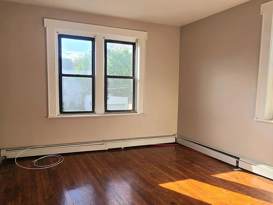 Large sunny living room with beautifully refinished hardwood floors