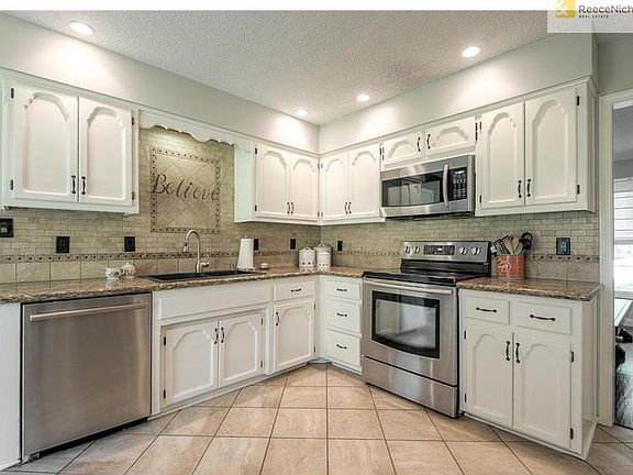 Super functional and beautiful too! Gorgeous backsplash. "Believe" sign is hanging in front. It is not a permanent part of the backsplash over the sink. Added recessed lighting throughout.