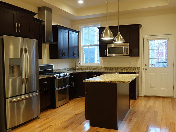 Kitchen with gas double oven and range and stainless steel appliances.