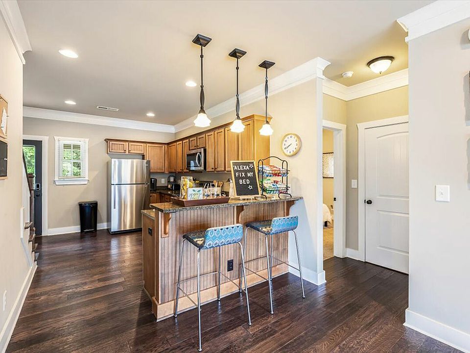 Modern kitchen with bar seating at The Cottages of Hattiesburg.