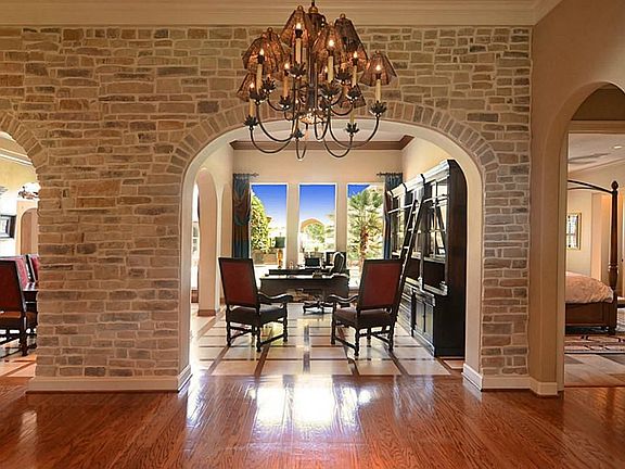 Guests entering the Foyer will first observe the massive stone arches that open to, and yet seclude, both the Living Room and Dining Rooms. Then, they notice the engaging views and the radiance from natural light reflecting exquisite wood floors.