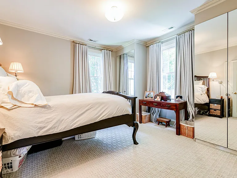 Bedroom with two built-in armoires with mirror doors.