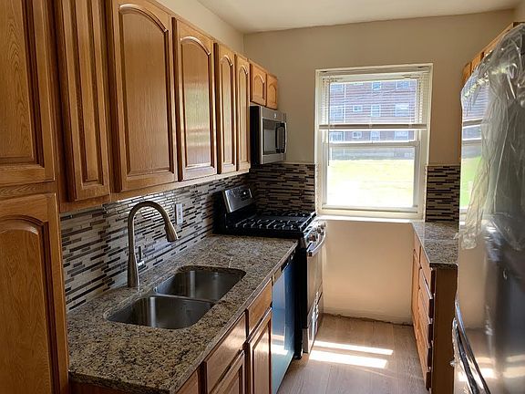 NEW COUNTERS AND BACKSPLASH. DOUBLE STAINLESS STEEL SINK WITH PULL OUT SPRAYER