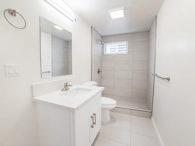 Floor to ceiling tiled shower, snow white quartz counter top