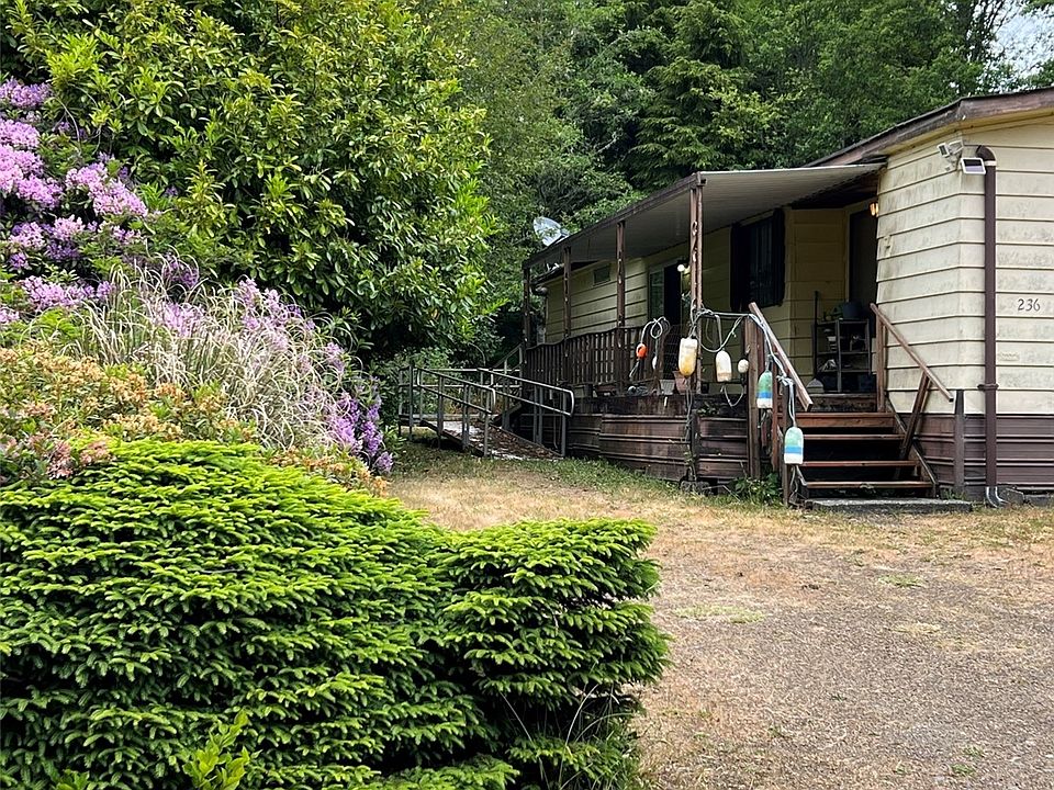 Side yard with ramp, nice shrubs.>