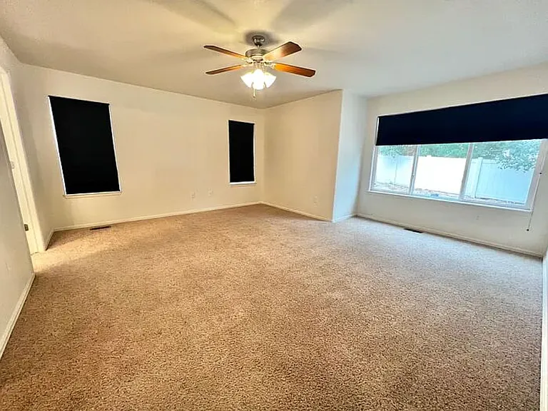 Very large master bedroom as viewed from the bedroom door. Southern-facing bay window. Walk-in master closet is to the left (not visible in photo), then the door to the master bathroom (visible).