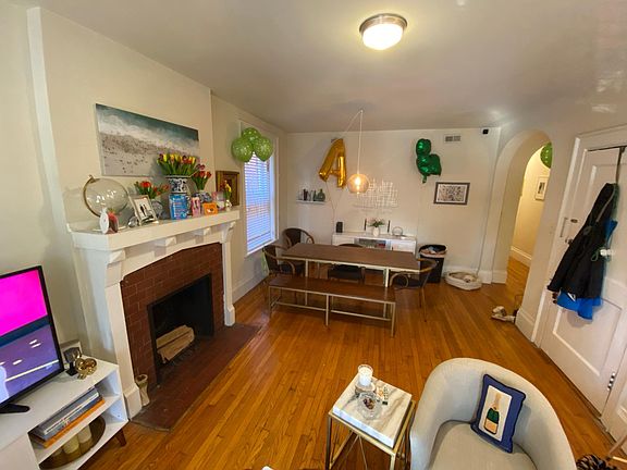 View of family/living room from porch door (front door is seen on the right with coats hanging on it)