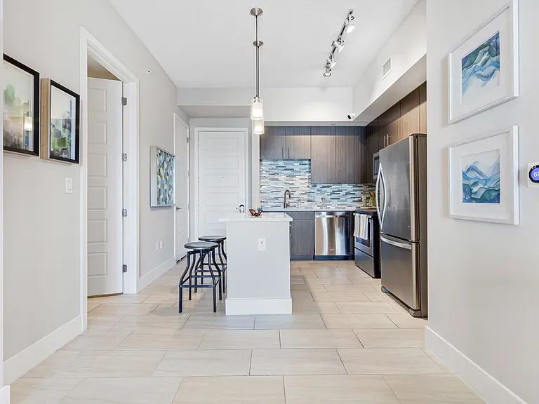 Model kitchen and dining room at our apartments in Boca Raton, featuring chairs around a table and counter seating.