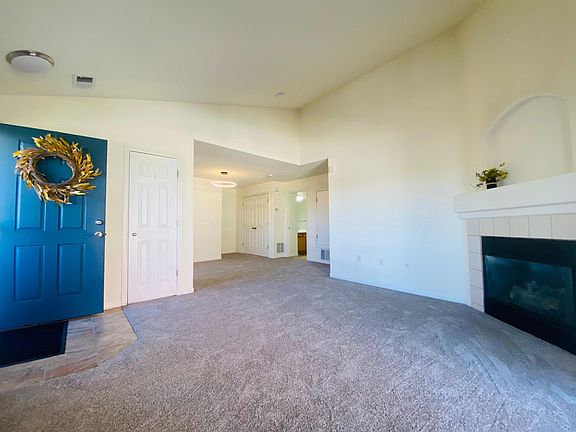 Open concept living, neutral decor, and vaulted ceilings throughout