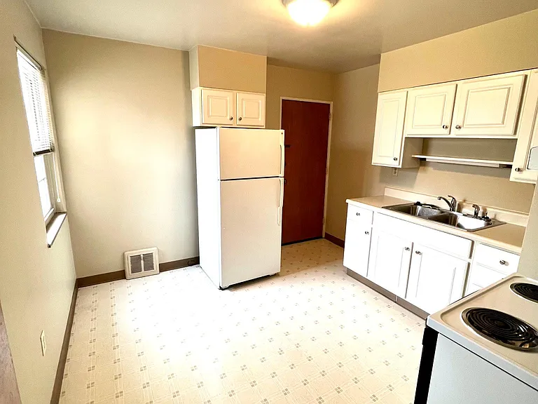 Kitchen with large window and eating area.