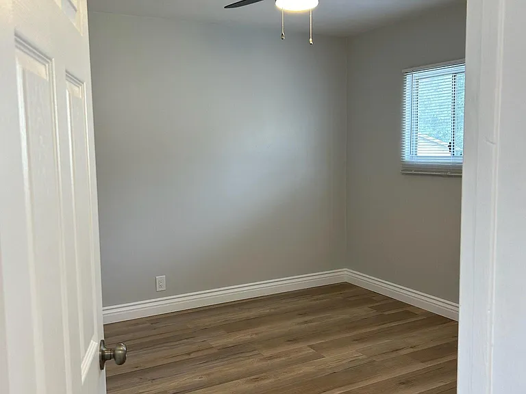 Entrance to bedroom with brand new designer door, laminate floors, blinds, ceiling lamp/fan and speciality paint.