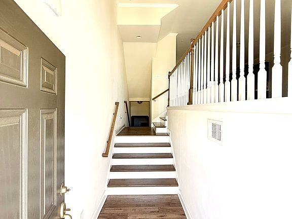 Bright and welcoming foyer with hardwood floors and natural light, setting the tone for the home's open and elegant design the moment you walk in.