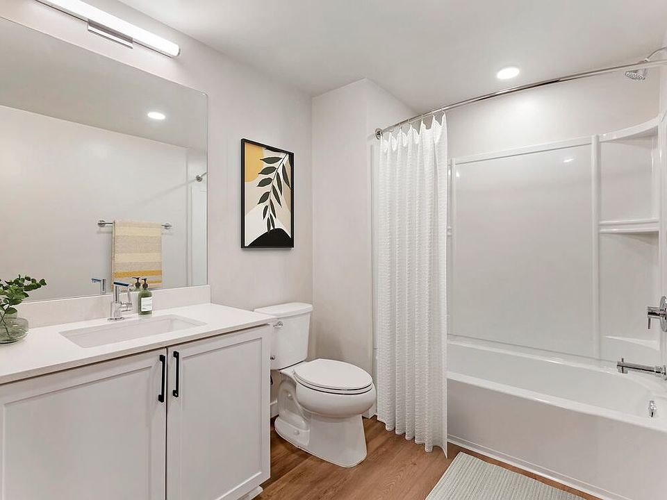 Renovated Package II bath with white quartz countertops, white cabinetry, and hard surface flooring