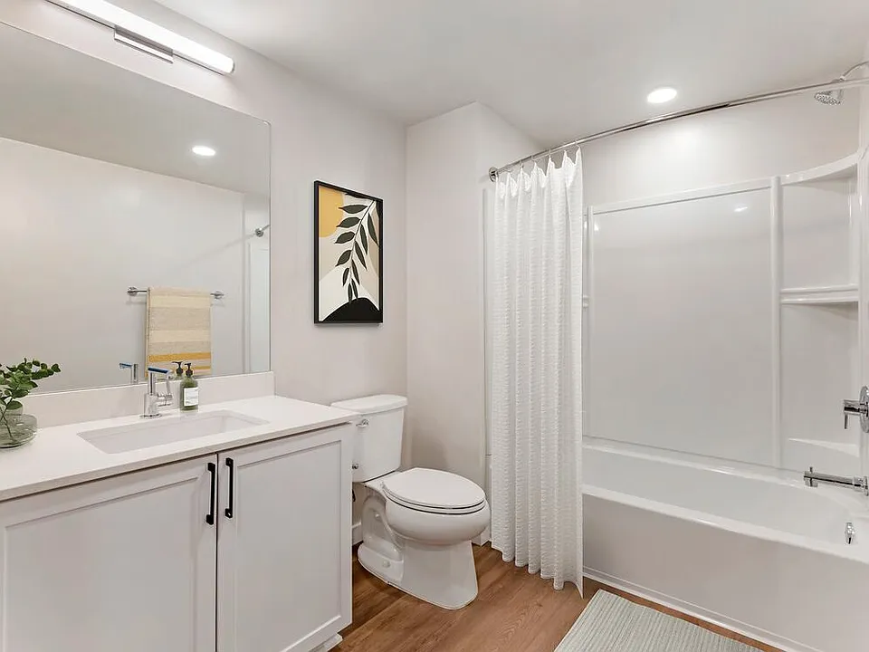 Renovated Package II bath with white quartz countertops, white cabinetry, and hard surface flooring