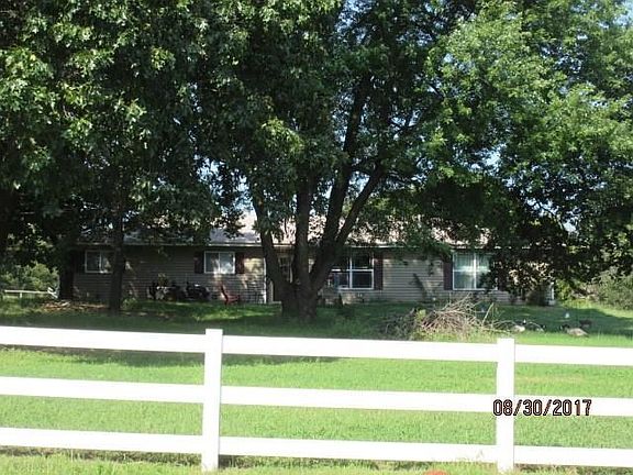 Impressive Curb Appeal with white fencing, large trees and quiet country living!
