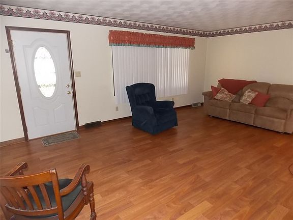 Large 19X13 living room with laminate hardwood floor, guest closet, and large picture window.
