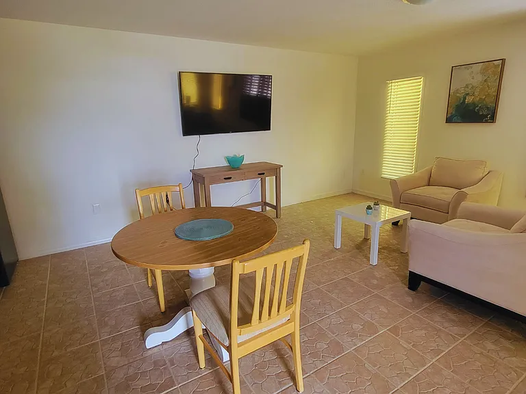 Charming wooden dining table for two, conveniently located near the living area and TV