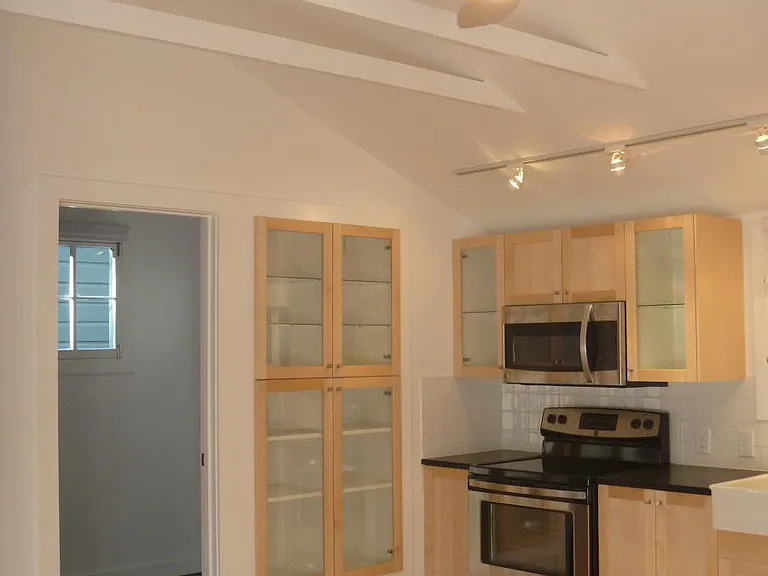 Kitchen with stove, microwave and glass cabinets