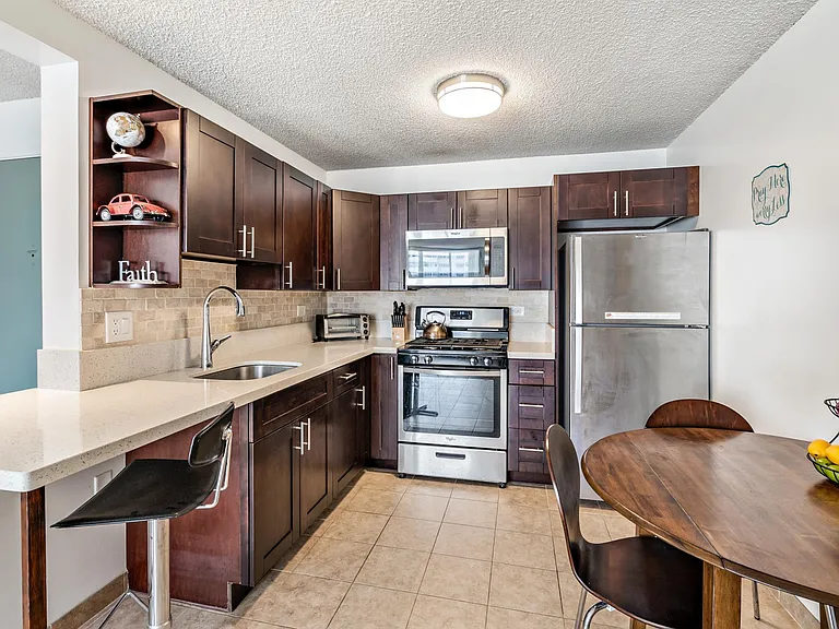 Kitchen with expandable table, bar chairs, gas stove, microwave, toaster oven , mixer, blender, complete table service and cookware