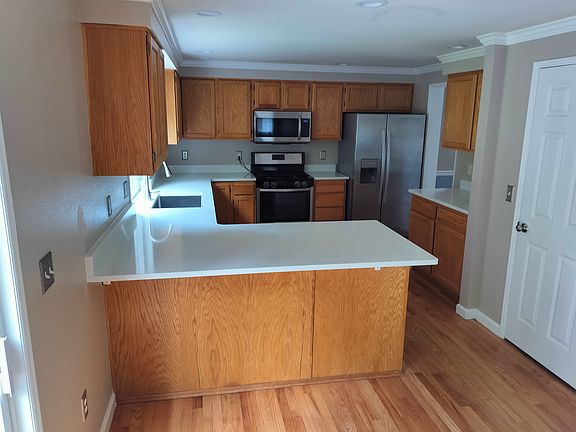 Kitchen with new quartz countertops, deep stainless steel sink and refinished hardwood flooring